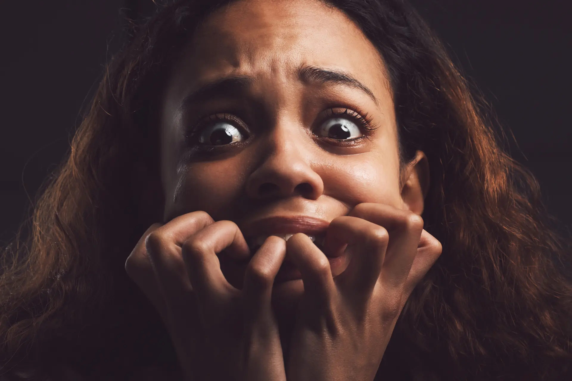 A frightened woman covering her mouth with her hands