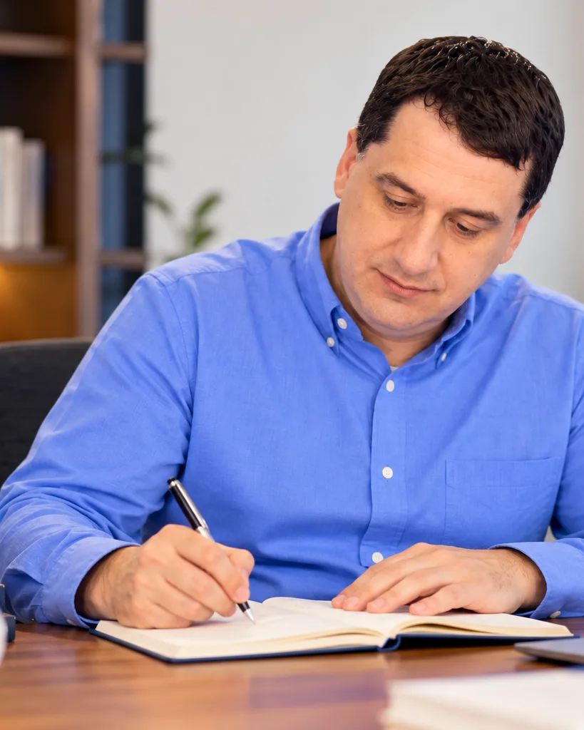 Stan Popovich writing at his desk